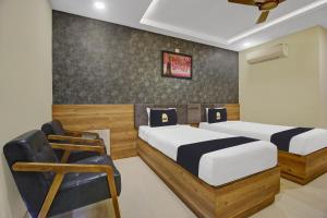 Collection O Hotel Swagath Pride في Mancherāl: غرفة نوم بسريرين وكرسي