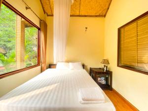 a bedroom with a large bed and a window at Tam Coc Rocky Bungalow in Ninh Binh