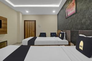 um quarto de hotel com duas camas e duas cadeiras em Collection O Hotel Swagath Pride em Mancherāl