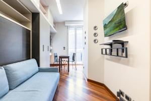 a living room with a couch and a tv on a wall at Easylife - Moderno rifugio in zona Bocconi in Milan