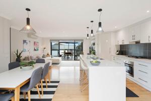 uma cozinha e sala de estar com mesa e cadeiras em Plan Beach em Merimbula