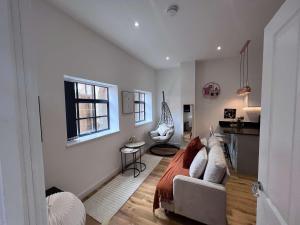 a bedroom with a bed and a couch and a window at Luxury Birmingham 2 Bedroom Town House in Birmingham