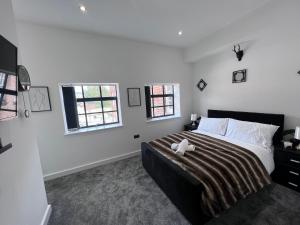 a bedroom with a large bed and two windows at Luxury Birmingham 2 Bedroom Town House in Birmingham