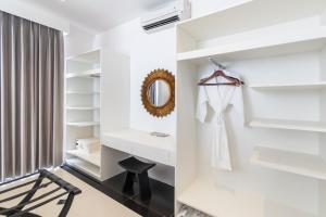 a white bathroom with a vanity and a mirror at Shanti Retreat in Seminyak