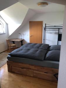 1 cama en un dormitorio con escritorio y 1 cama sidx sidx sidx sidx en Ferienwohnung auf dem Maifeld, en Gappenach
