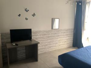 a bedroom with a flat screen tv on a table at Raggio di Sole in San Cesareo