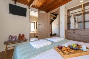a bedroom with a bed with a tray of food on it at Historic Villa Kassiopi with Panoramic Sea view in Epáno Kefalás