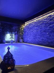 a swimming pool lit up at night in a house at Le Clos des Thermes Suites de Luxe avec wellness privatif in Chaudfontaine