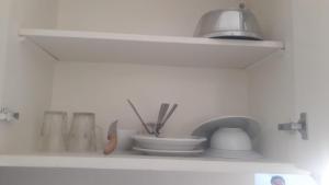 a white shelf with bowls and utensils on it at Moubark 6 Studio in Hurghada