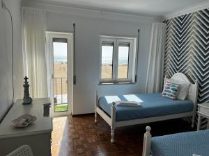 ein Schlafzimmer mit einem Bett und zwei Fenstern in der Unterkunft Flipflops Apartments 1 in Nazaré