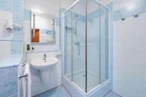 a bathroom with a glass shower and a sink at Apartmán C409 v areálu Wellness hotelu Frymburk in Frymburk +27 photos