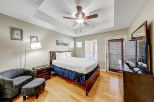 Un dormitorio con una cama y un ventilador de techo. en Texas Two Steps From Beach, en Padre Island