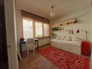 a bedroom with a bed and a desk and a chair at La Casa del Río in Zamora