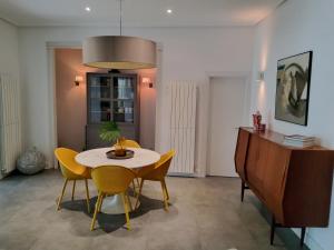 a dining room with a table and yellow chairs at La Casa del Río in Zamora