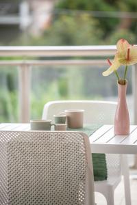 een roze vaas met een bloem op een tafel bij Le Dimore di Giò in Ortona