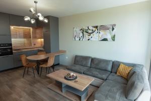 a living room with a couch and a table at Riverview apartment - Free Private Parking in Plovdiv