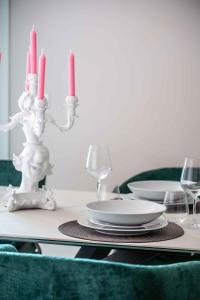 uma mesa com velas vermelhas, pratos e taças de vinho em Le Dimore di Giò em Ortona