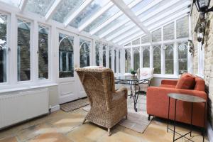 a conservatory with a glass ceiling and chairs and a table at The Stow Secret Cottage - Breathtaking 5BDR Cottage with Parking & Garden in Stow on the Wold