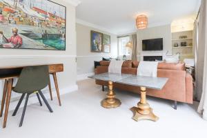 uma sala de estar com um sofá e uma mesa em The Stow Secret Cottage - Breathtaking 5BDR Cottage with Parking & Garden em Stow on the Wold