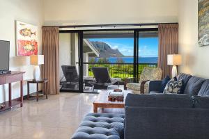 - un salon avec un canapé bleu et une vue sur l'océan dans l'établissement Hanalei Bay Resort 7307, à Princeville