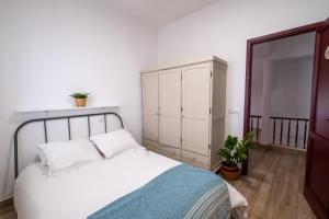 een slaapkamer met een wit bed en een kast bij Casa Abuela Toña by Huskalia - city center in Los Llanos de Aridane