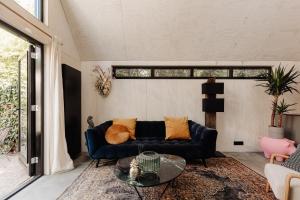 a living room with a blue couch and a glass table at Studio Verver in Bergen