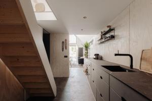 a kitchen with a sink and a staircase in a room at Studio Verver in Bergen