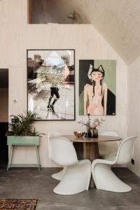 a dining room with a table and two paintings on the wall at Studio Verver in Bergen