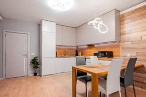 a kitchen and dining room with a wooden table and chairs at Urban Elegance at Its Finest Stylish 1-BD Flat in Sofia