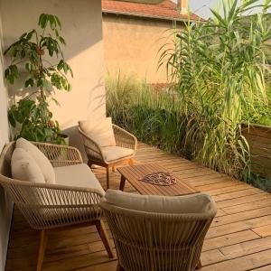 eine Terrasse mit 2 Stühlen und einem Tisch auf einer Terrasse in der Unterkunft Superbe studio tendance et zen proche de Lyon in Couzon-au-Mont-dʼOr