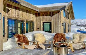 dom pokryty śniegiem z krzesłami i stołami w obiekcie 5 Bedroom Stunning Home In Vringsfoss w mieście Maurset