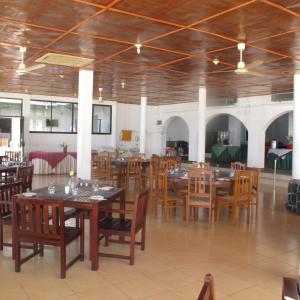 a dining room with wooden tables and chairs at Sea Lotus Park in Trincomalee
