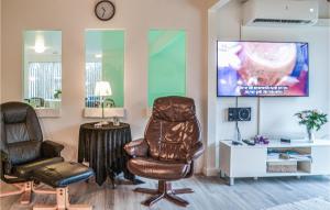 - une salle d'attente avec 2 chaises et une télévision dans l'établissement Awesome Home In Oksbl With Kitchen, à Oksbøl