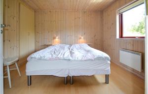Lønne HedeにあるAmazing Home In Nrre Nebel With 3 Bedrooms, Sauna And Wifiの窓のある木製の壁のドミトリールームのベッド1台分です。