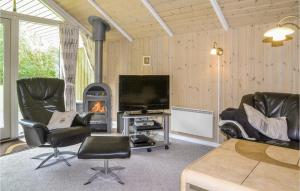 sala de estar con sillas, TV y chimenea en Awesome Home In Oksbl With Sauna, en Oksbøl