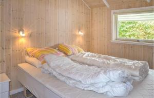 un sofá cubierto de sábanas en una habitación con ventana en Awesome Home In Oksbl With Sauna, en Oksbøl