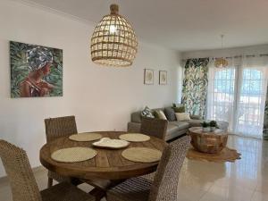 uma sala de estar com uma mesa de madeira e cadeiras em Villa coralin em Morro del Jable