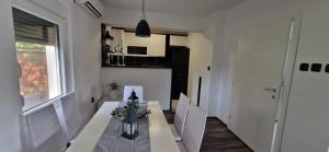 ein Esszimmer mit einem Tisch und einer Küche in der Unterkunft Vila Elena in Niš