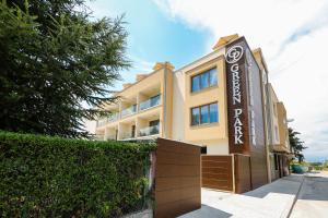 a building with a sign in front of it at Hotel Green Park Service Perfected in Garmen