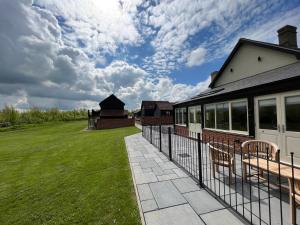 a fence in front of a house with a yard at White House Lodges in Heveningham