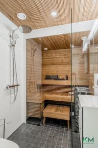 a bathroom with a shower and a tub with a sink at Kotimaailma - Kaunis ja hyvin valoisa kaksio Vantaalta in Vantaa