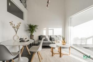 a living room with two tables and a couch at Kotimaailma - Kaunis ja hyvin valoisa kaksio Vantaalta in Vantaa