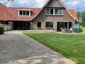 een huis met een patio en een grasveld bij Erve Toon'boer in Mander