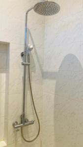 a shower with a shower head in a bathroom at Nata Villa Syariah close to Telkom in Bandung