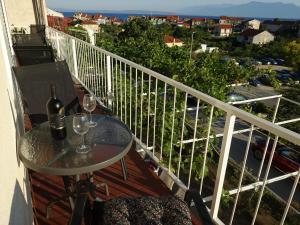 a table with two glasses of wine on a balcony at Klimatisiertes Apartment Barbara in Trpanj