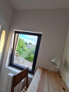 a window in a room with a table and a lamp at Studio en plein centre-ville de Perros-Guirec in Perros-Guirec
