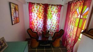 una mesa y 2 sillas en una habitación con cortinas en Jag Niwas Guest House & pure veg restaurant, en Udaipur
