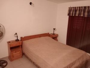 1 dormitorio con 1 cama, 2 mesitas de noche y ventana en Los nidos 2 en Villa Cura Brochero