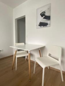 a white table and two white chairs in a room at Air Apartments 11 in Bremen