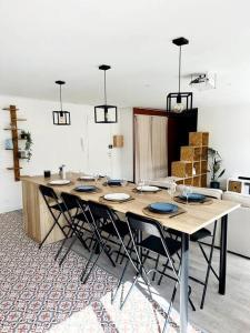 a large wooden table with chairs in a room at Convivial appartement de charme avec balcon , 95 m2 en hyper-centre de Saint-Brieuc. Tout confort, grand salon avec vidéoprojecteur - 3 chambres - Parking in Saint-Brieuc
